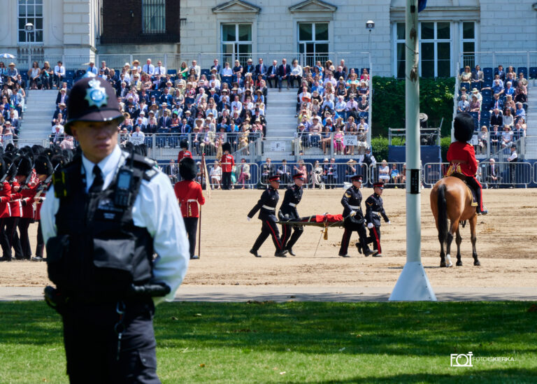 Gwardia królewska i policjant podczas zmiany warty w Londynie w Buckingham Palace i ceremonii „Beating Retreat.The photo sparkle is in London where the Changing of the Guard at Buckingham Palace and the "Beating Retreat" ceremony take place