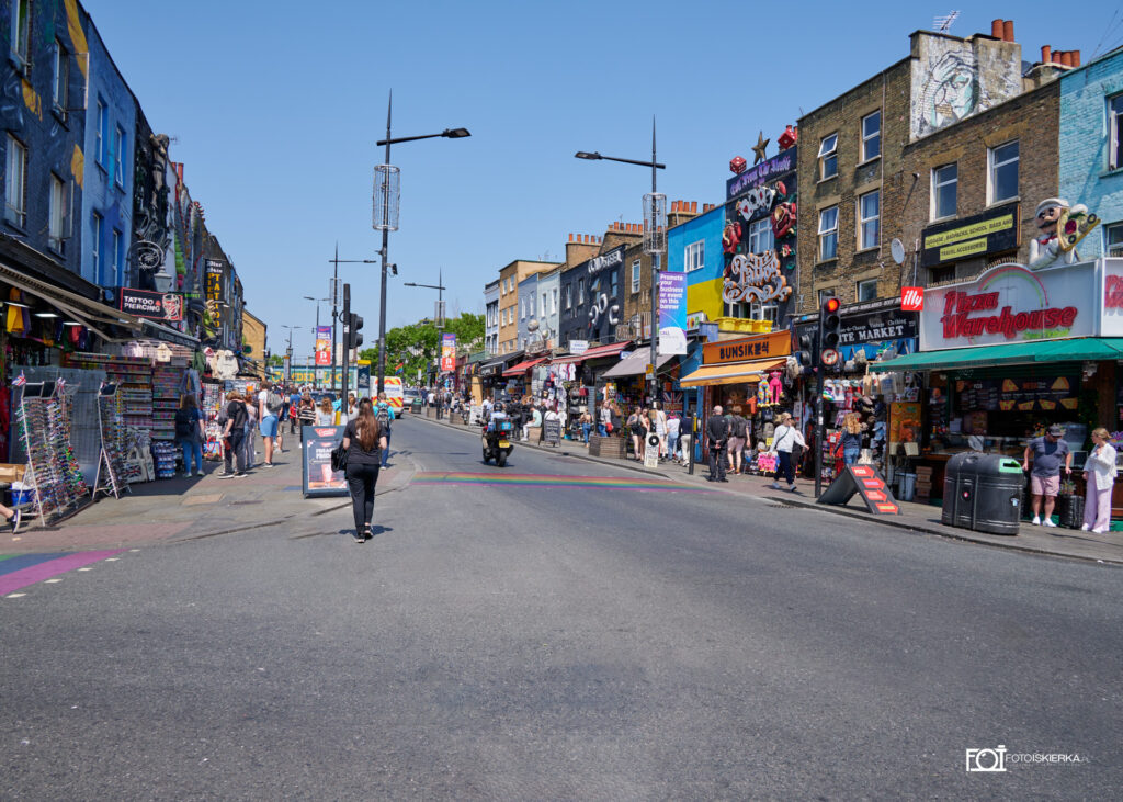 główna ulica w Camden Town w Londynie w Anglii. W tle kolorowe budynki pomalowane graffiti. Photo spark sees the high street in Camden Town, London, England. In the background, colorful buildings painted with graffiti.